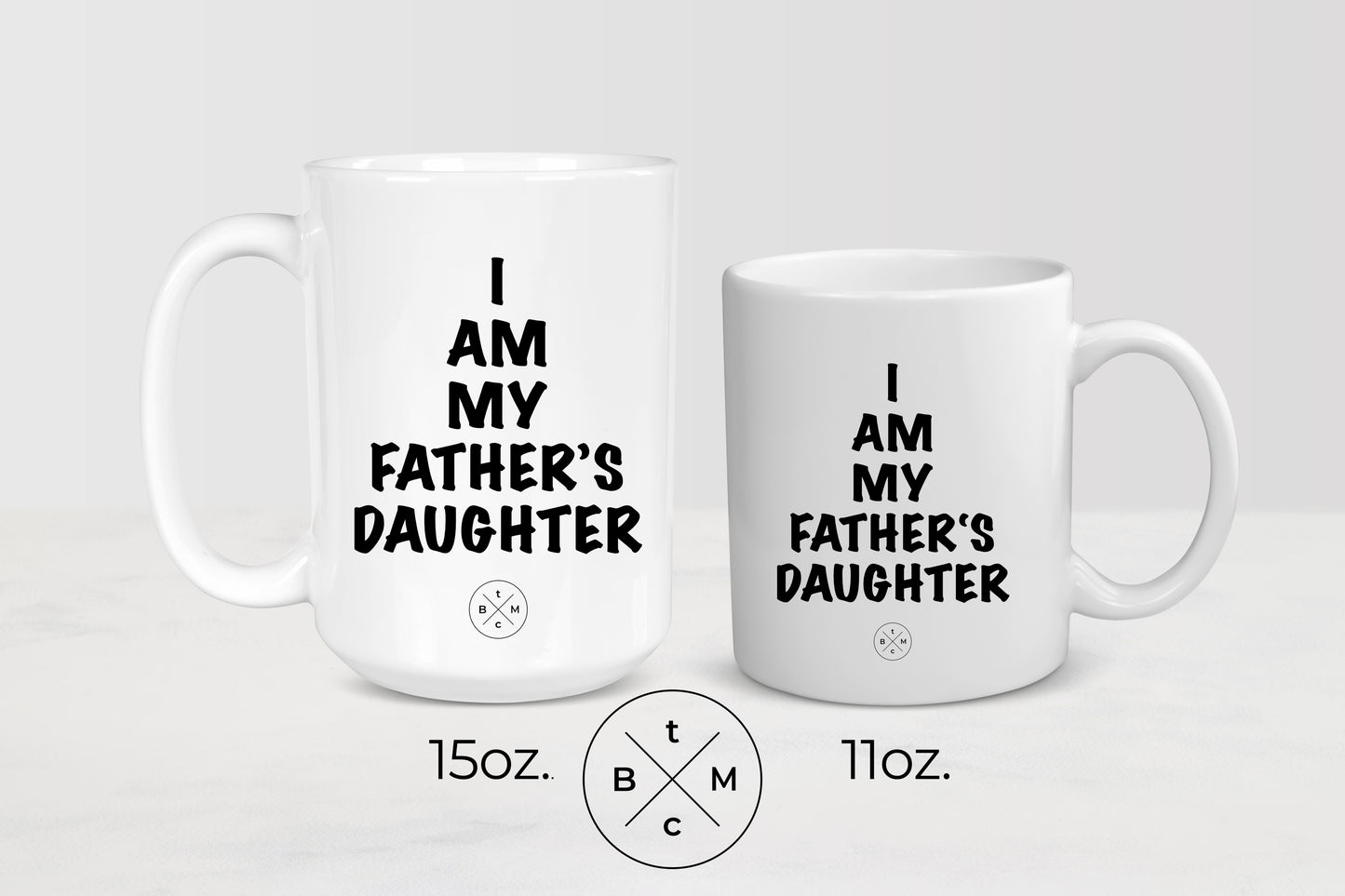 White 11 ounce and 15 ounce ceramic mugs with black text I am my father’s daughter