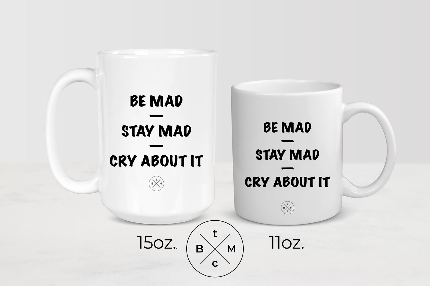 White 11 ounce and 15 ounce ceramic mugs with black text be mad stay mad cry about it