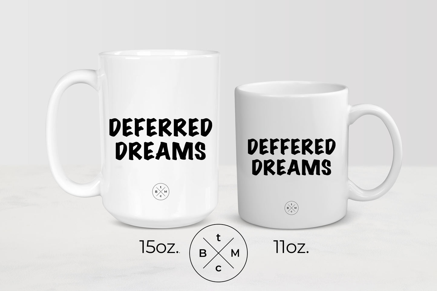 11 ounce and 15 ounce white ceramic mugs with black text deferred dreams