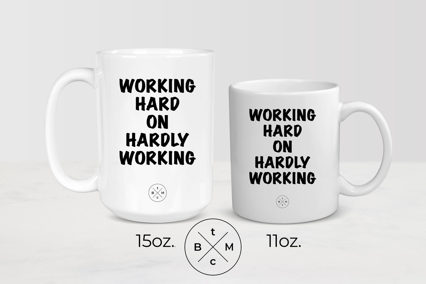 11 ounce and 15 ounce white ceramic mugs with black text working hard on hardly working