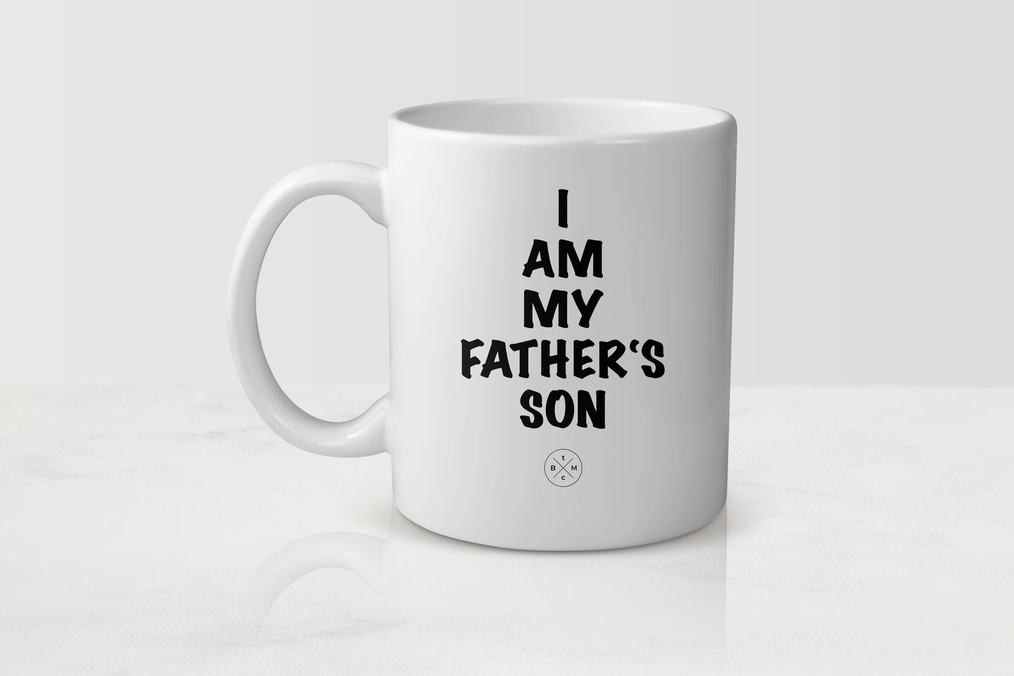 11 ounce white ceramic mug with black text I am my father’s son