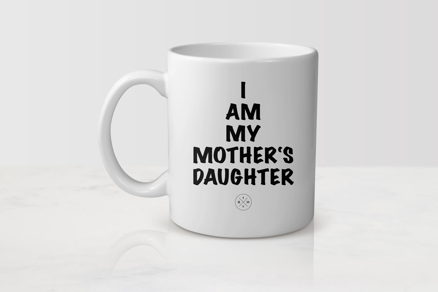 White 11 ounce ceramic mug with black text I am my mother’s daughter