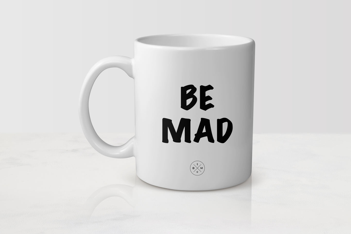 white 11 ounce ceramic mug with black text be mad