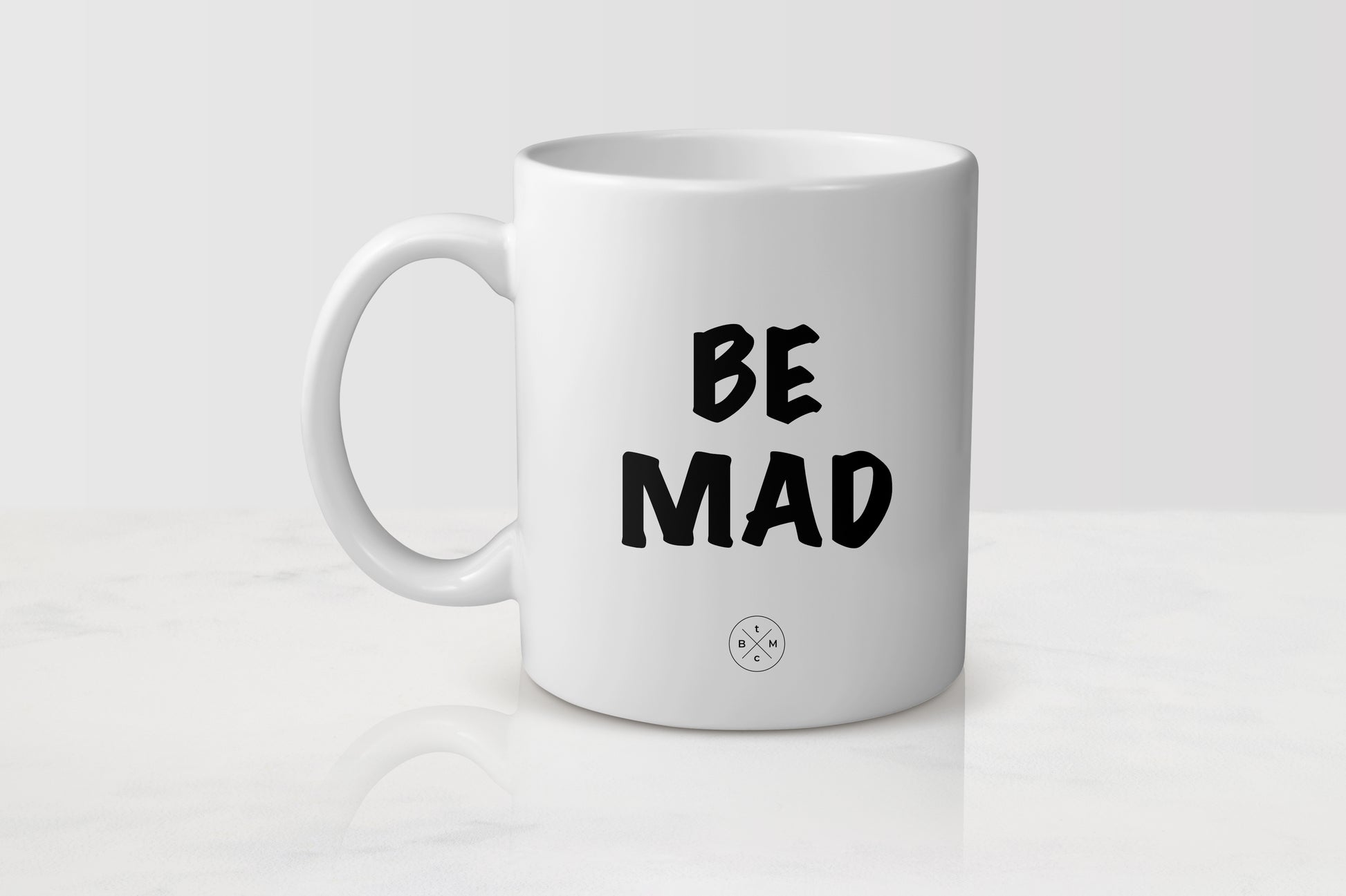 white 11 ounce ceramic mug with black text be mad
