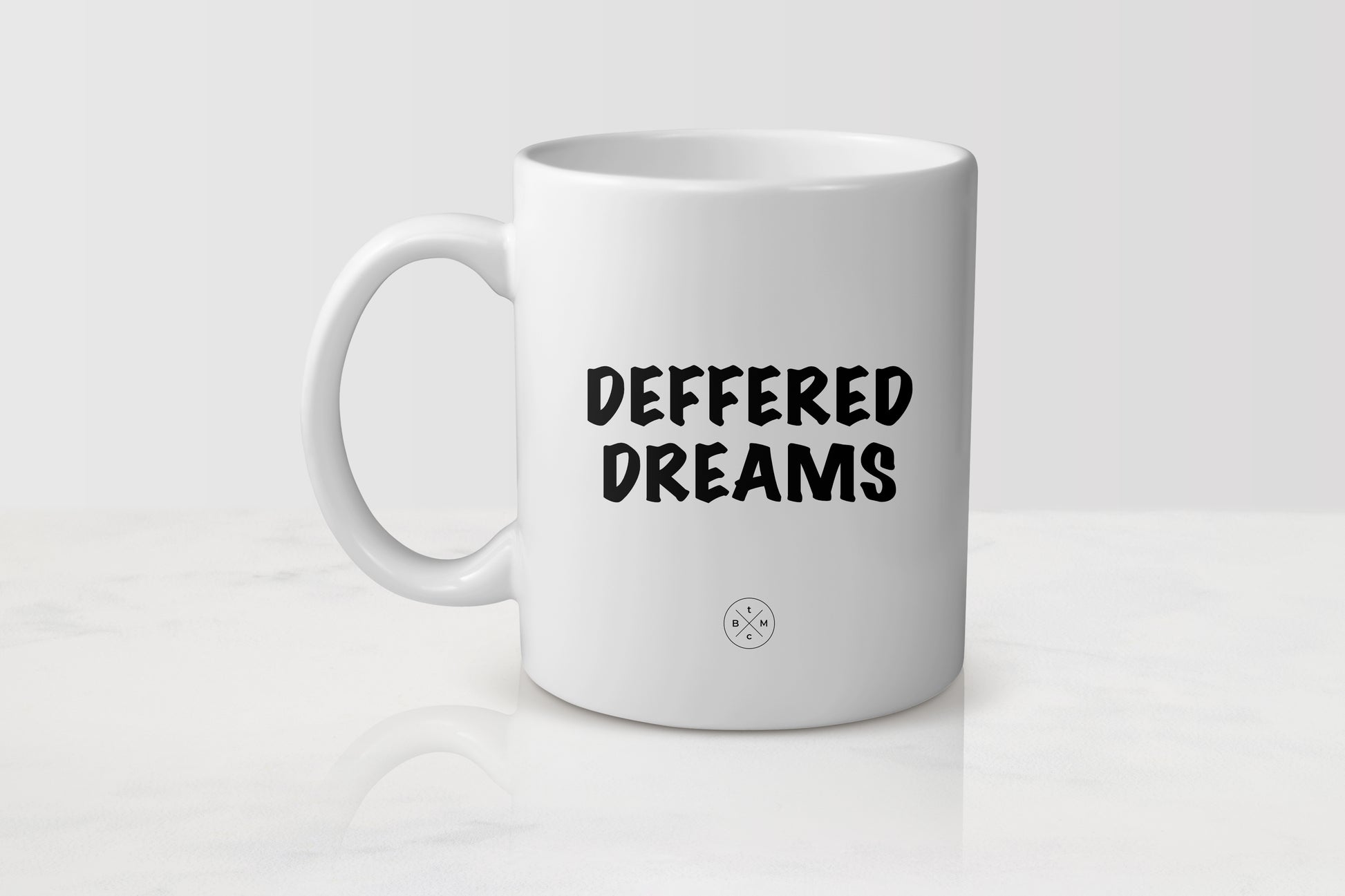 11 ounce white ceramic mug with black text deferred dreams
