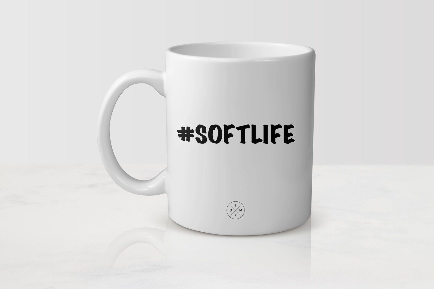 White 11 ounce ceramic mug with black text #SoftLife