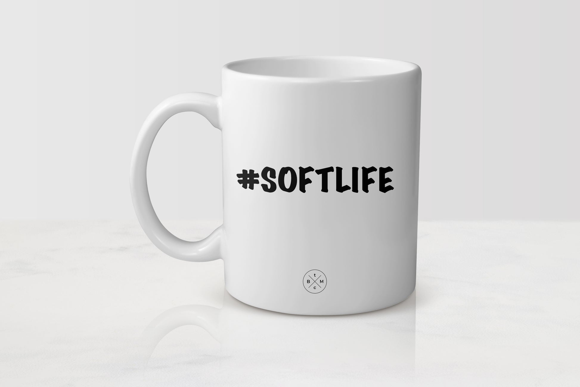 White 11 ounce ceramic mug with black text #SoftLife