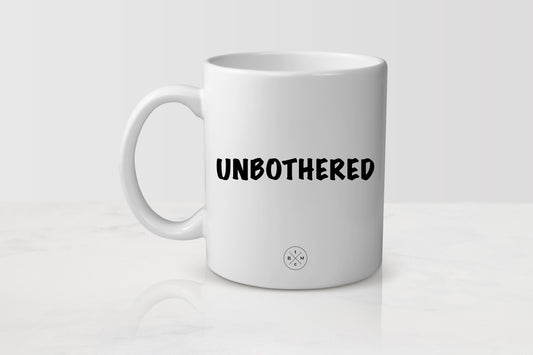 White 11 ounce ceramic mug with black text unbothered