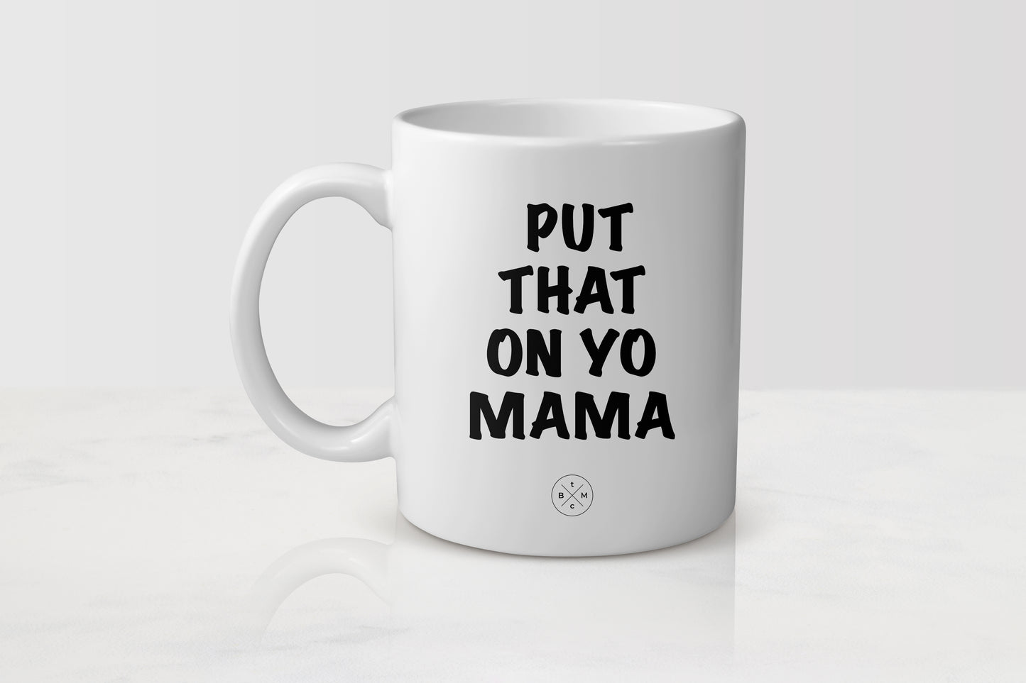 White 11 ounce mug with black text put that on yo mama