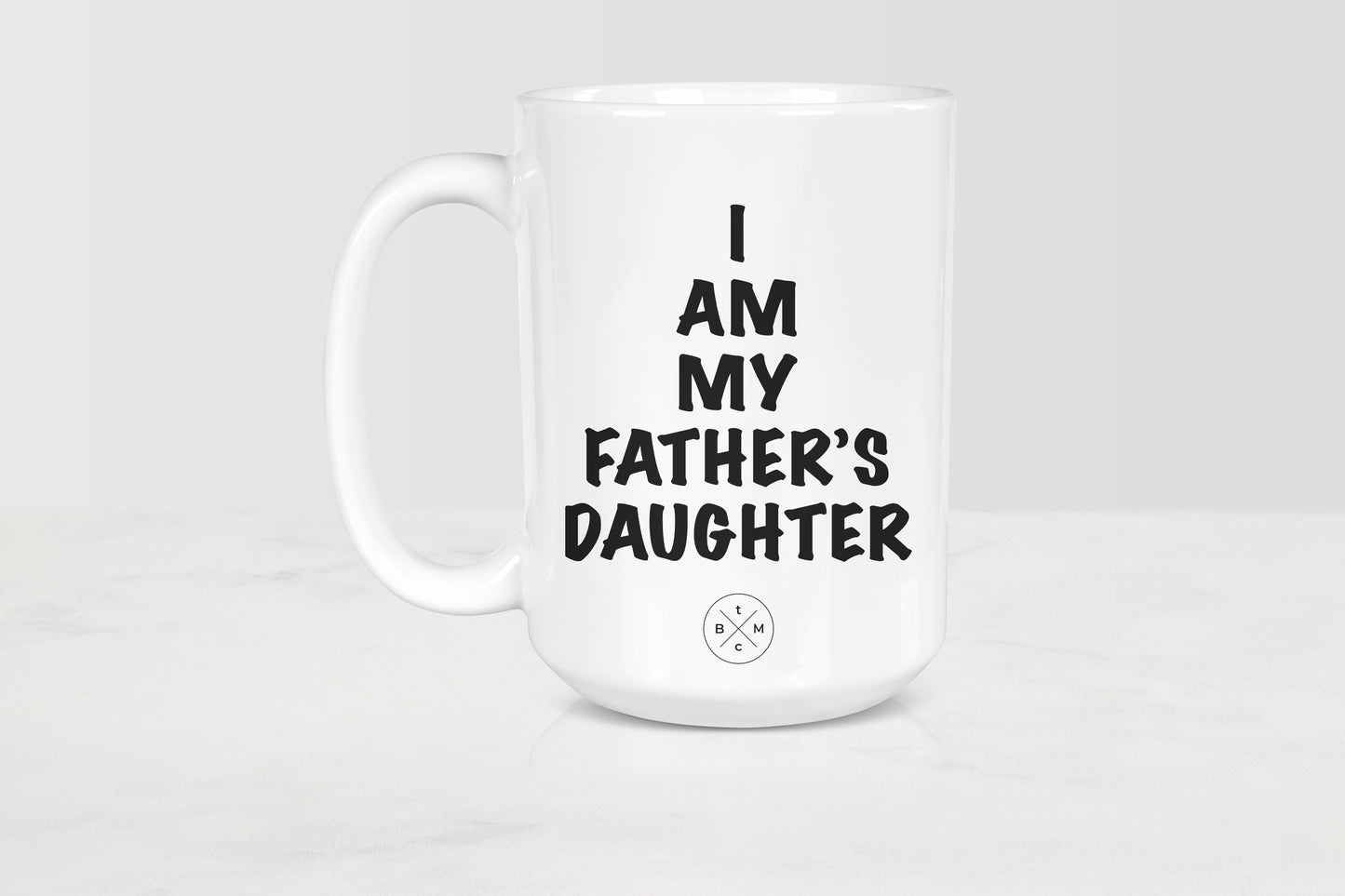 White 15 ounce ceramic mug with black text I am my father’s daughter