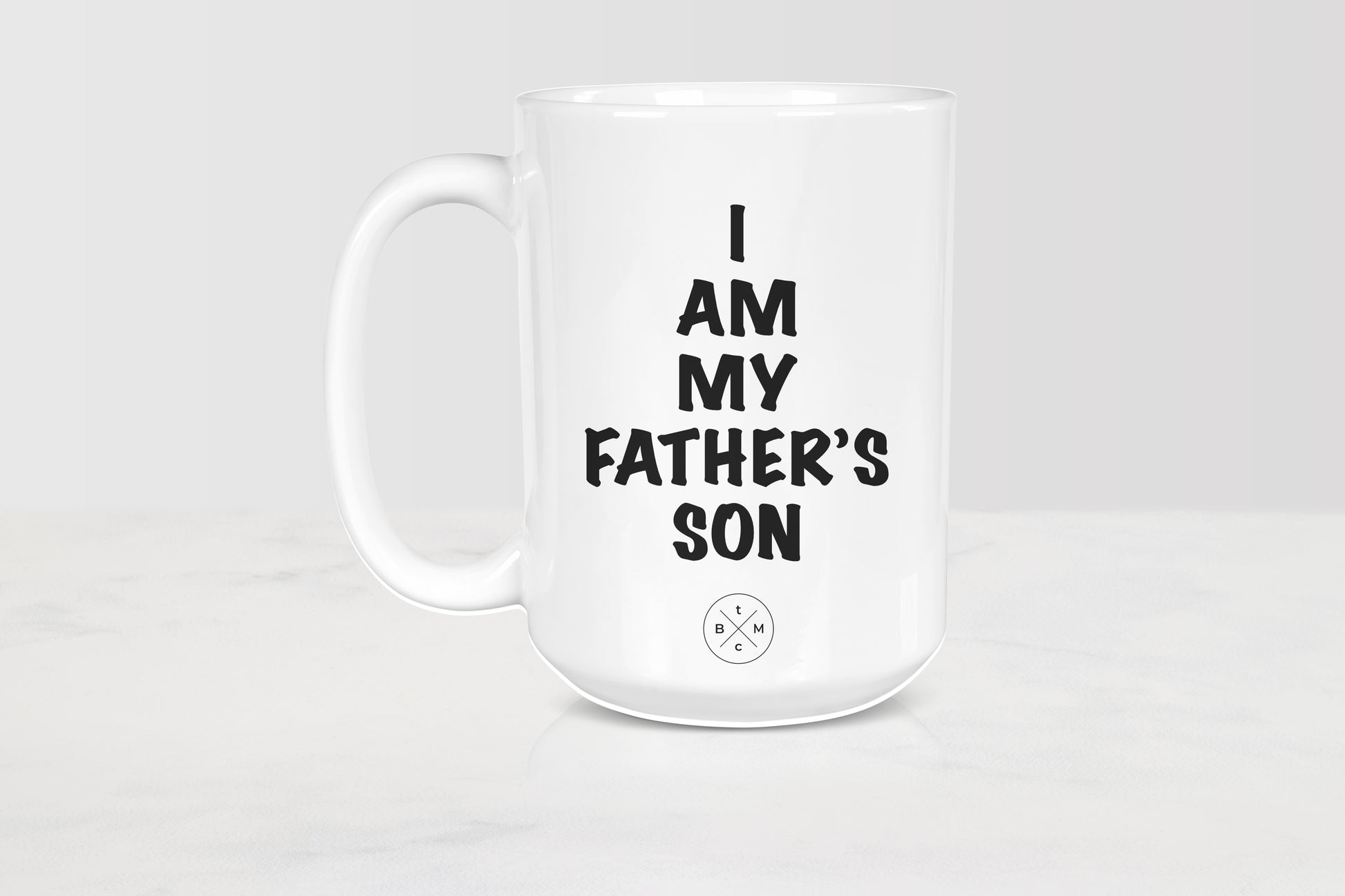15 ounce white ceramic mug with black text I am my father’s son