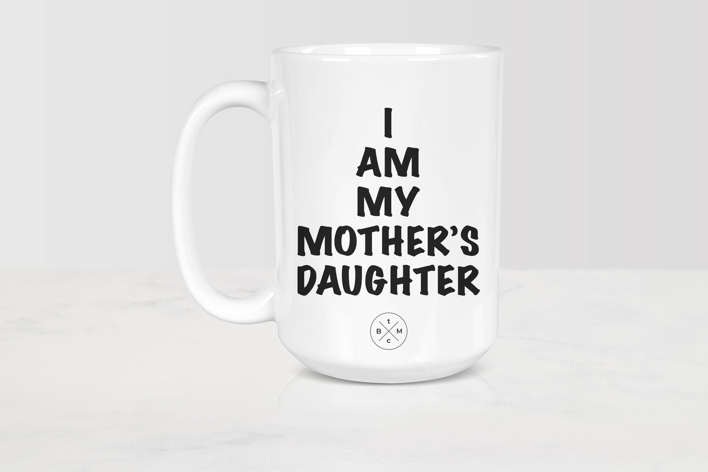 White 15 ounce ceramic mug with black text I am my mother’s daughter