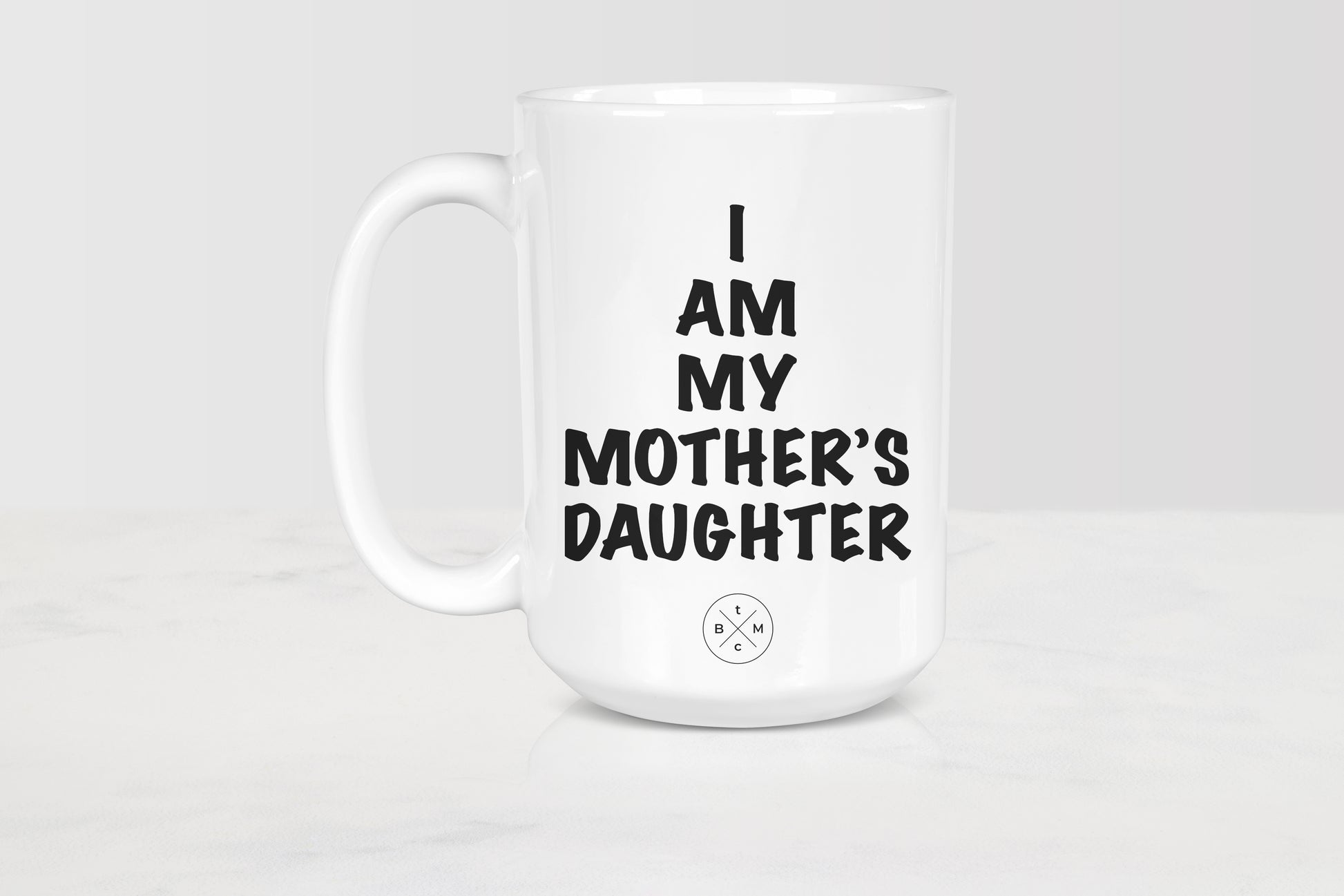 White 15 ounce ceramic mug with black text I am my mother’s daughter