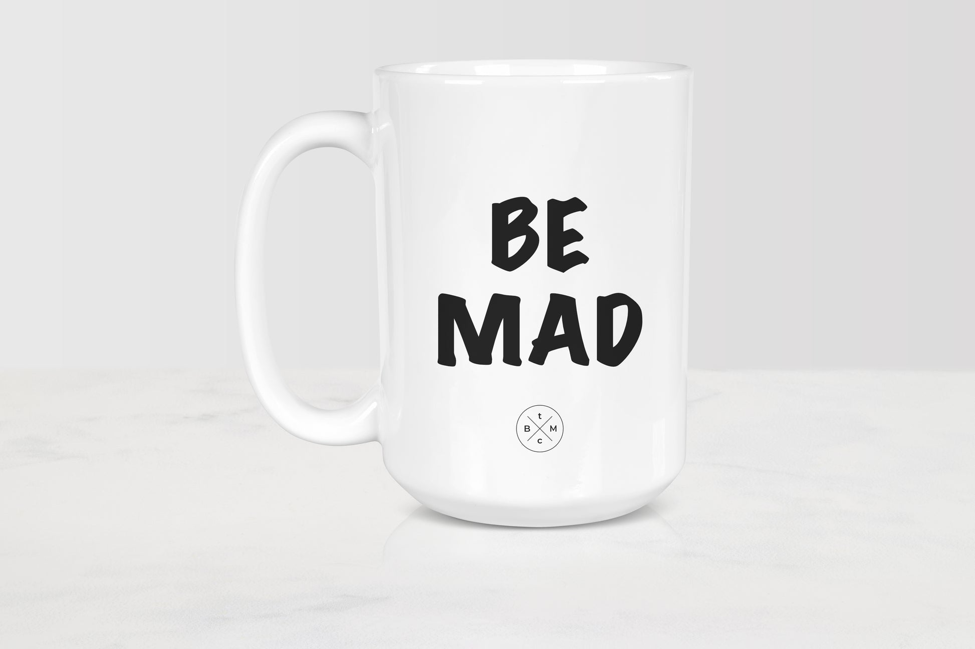White 15 ounce ceramic mug with black text be mad