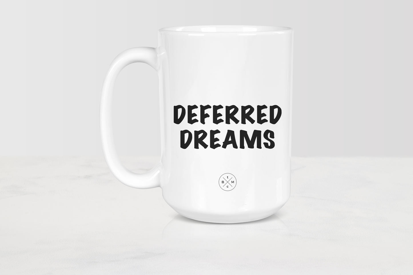 15 ounce white ceramic mug with black text deferred dreams