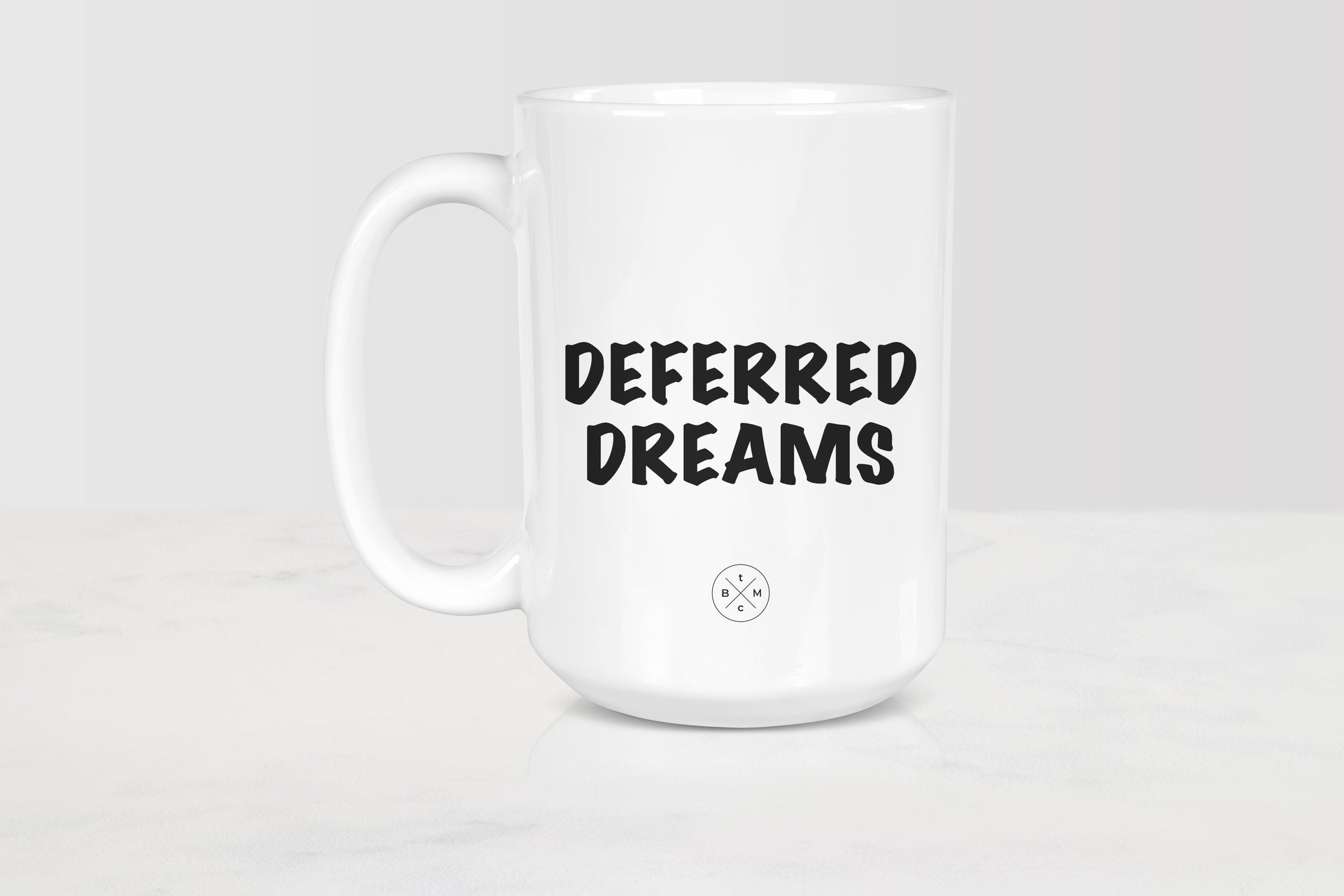 15 ounce white ceramic mug with black text deferred dreams