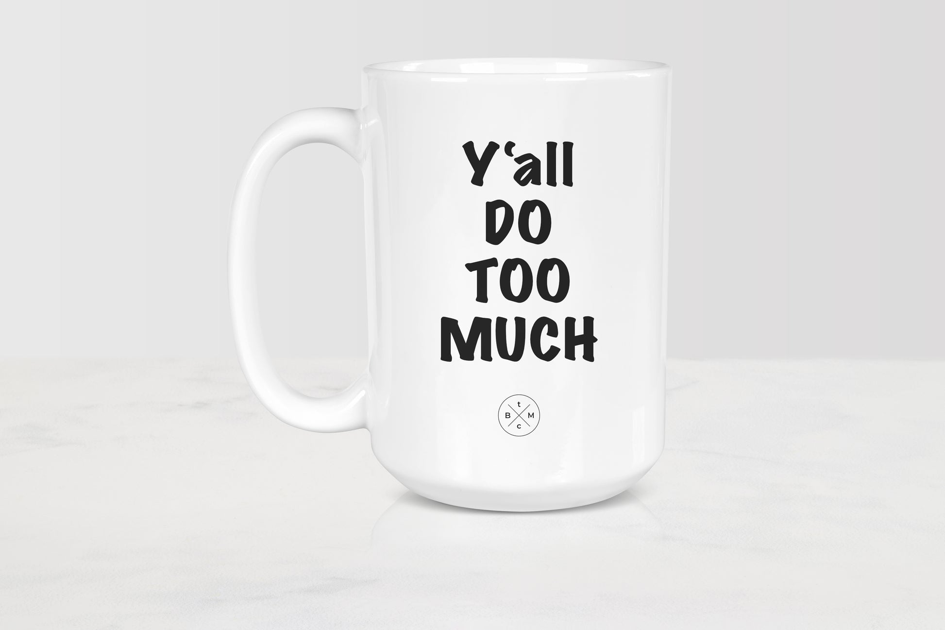 15 ounce white ceramic mug with black text y’all do too much
