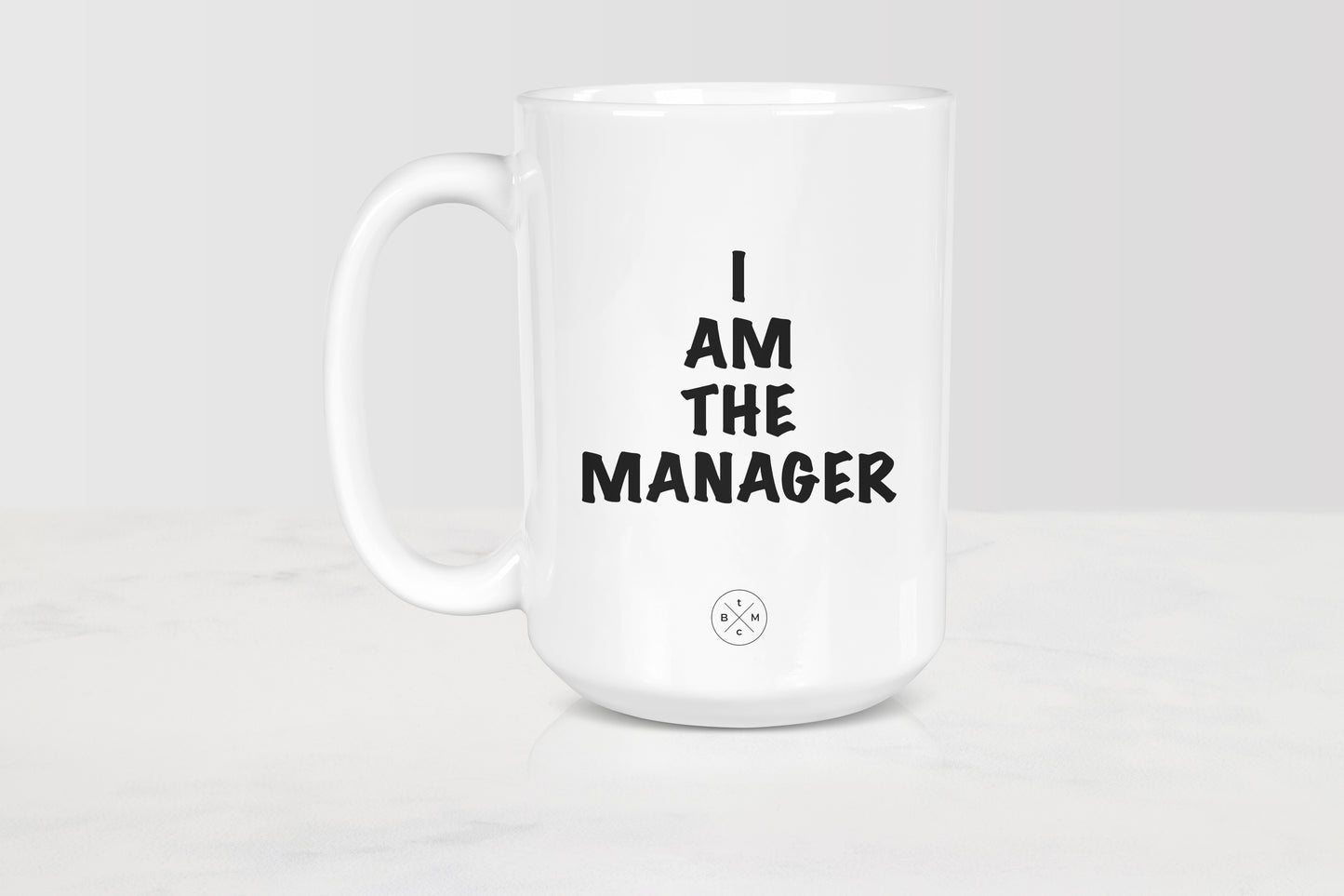 15 ounce white ceramic mug with black text I am the manager