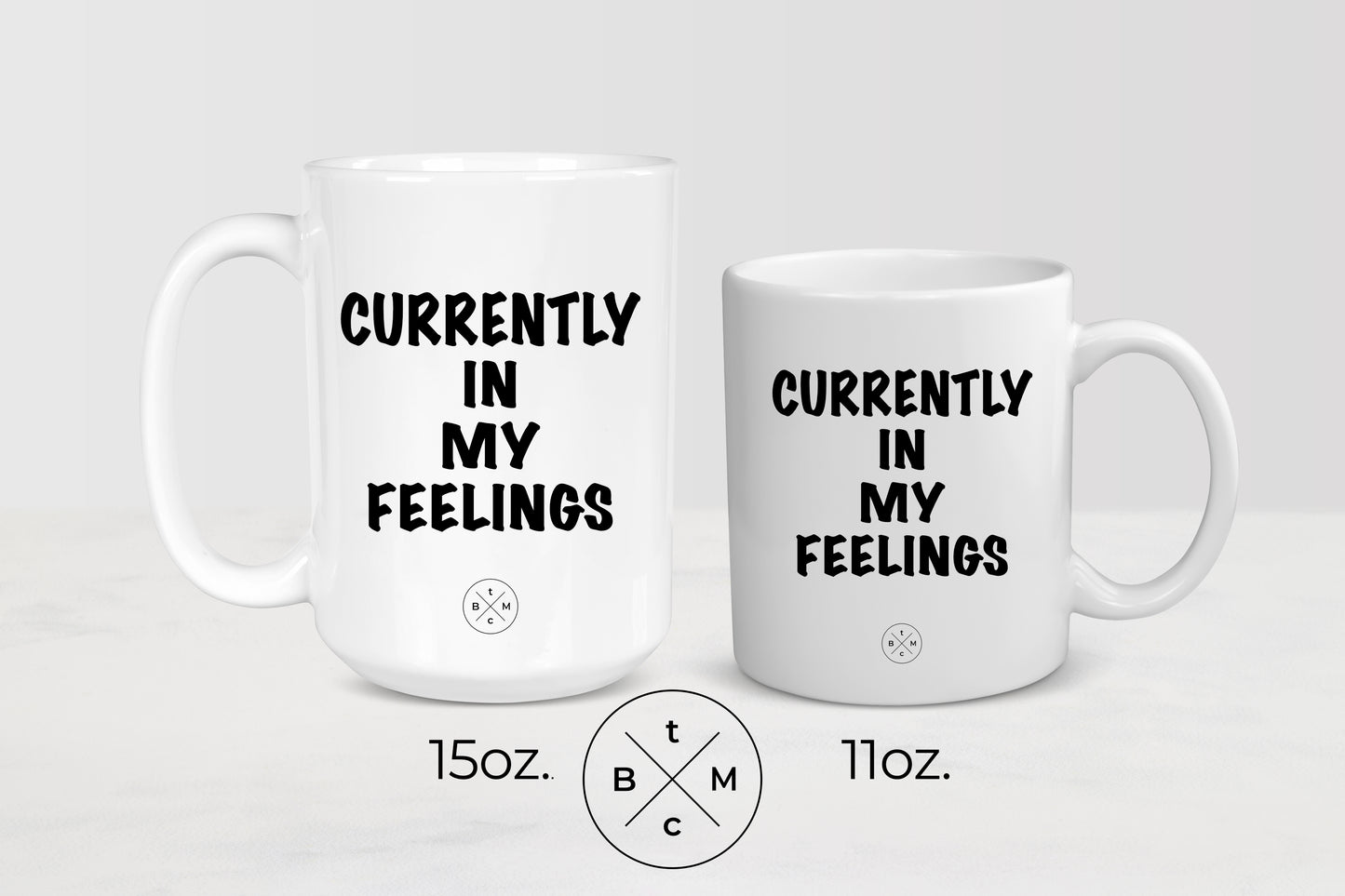 11 ounce and 15 ounce white ceramic mugs with black text currently in my feelings