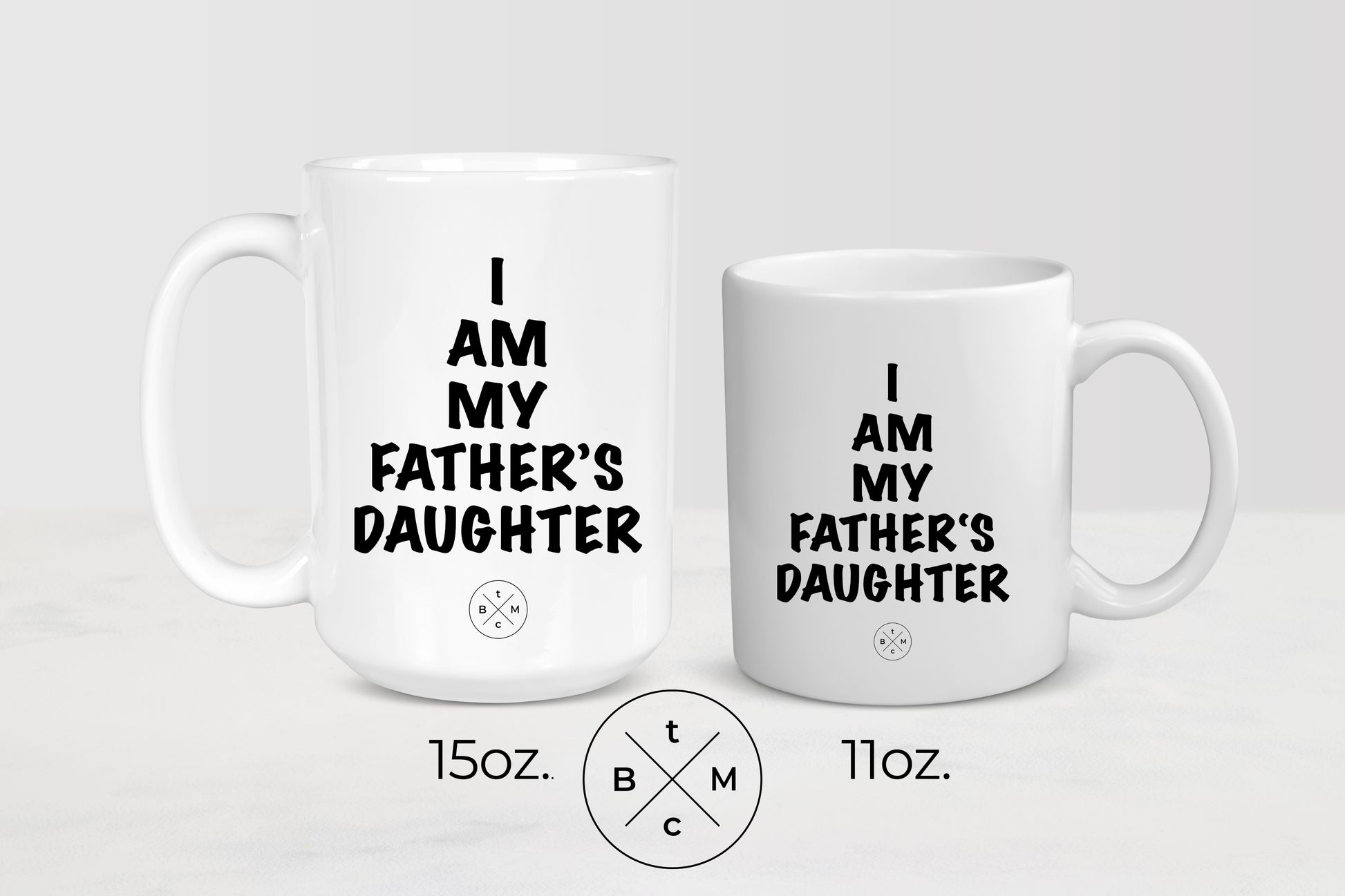 White 11 ounce and 15 ounce ceramic mugs with black text I am my father’s daughter