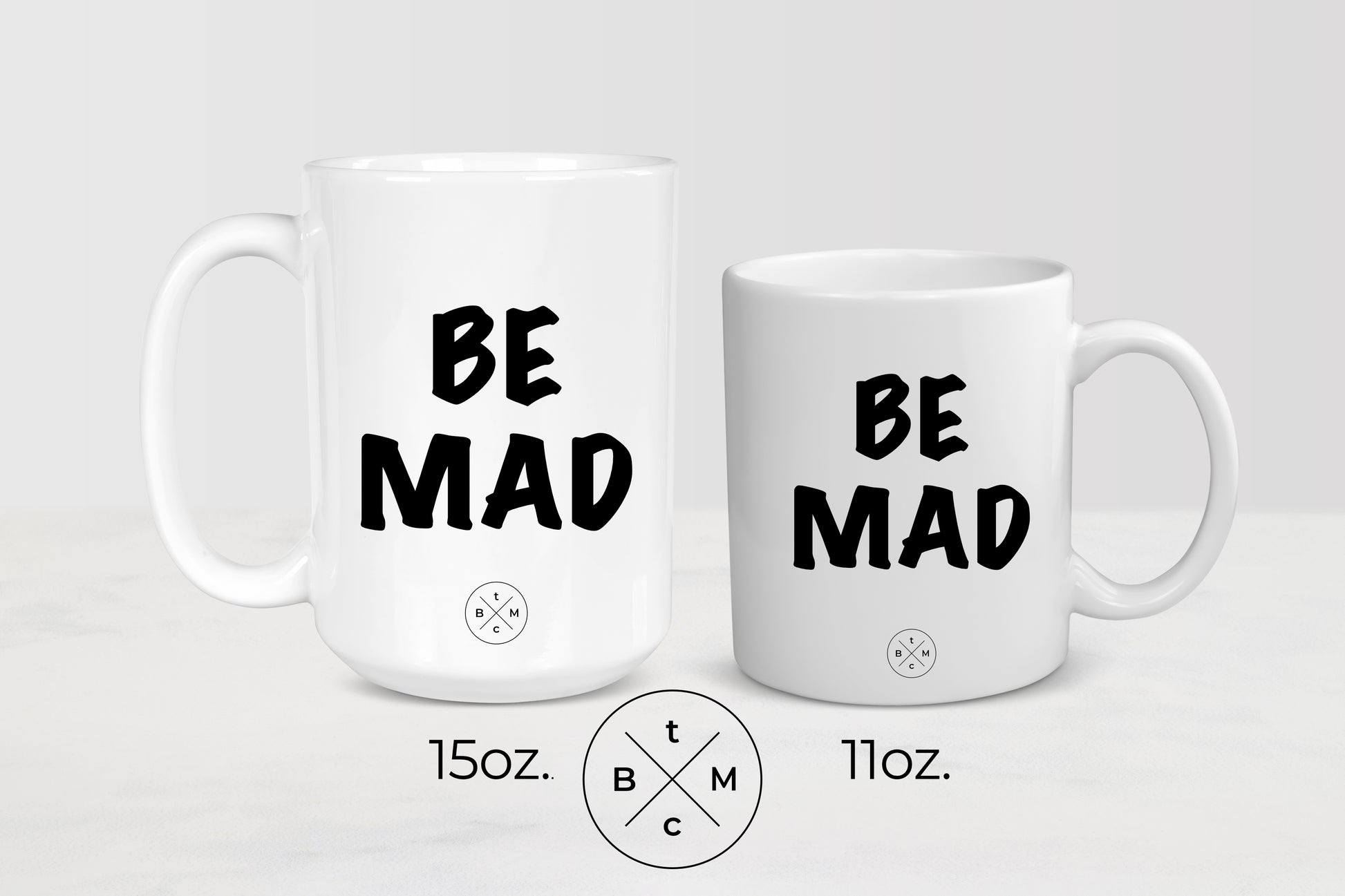 White 11 ounce and 15 ounce mug with black text be mad
