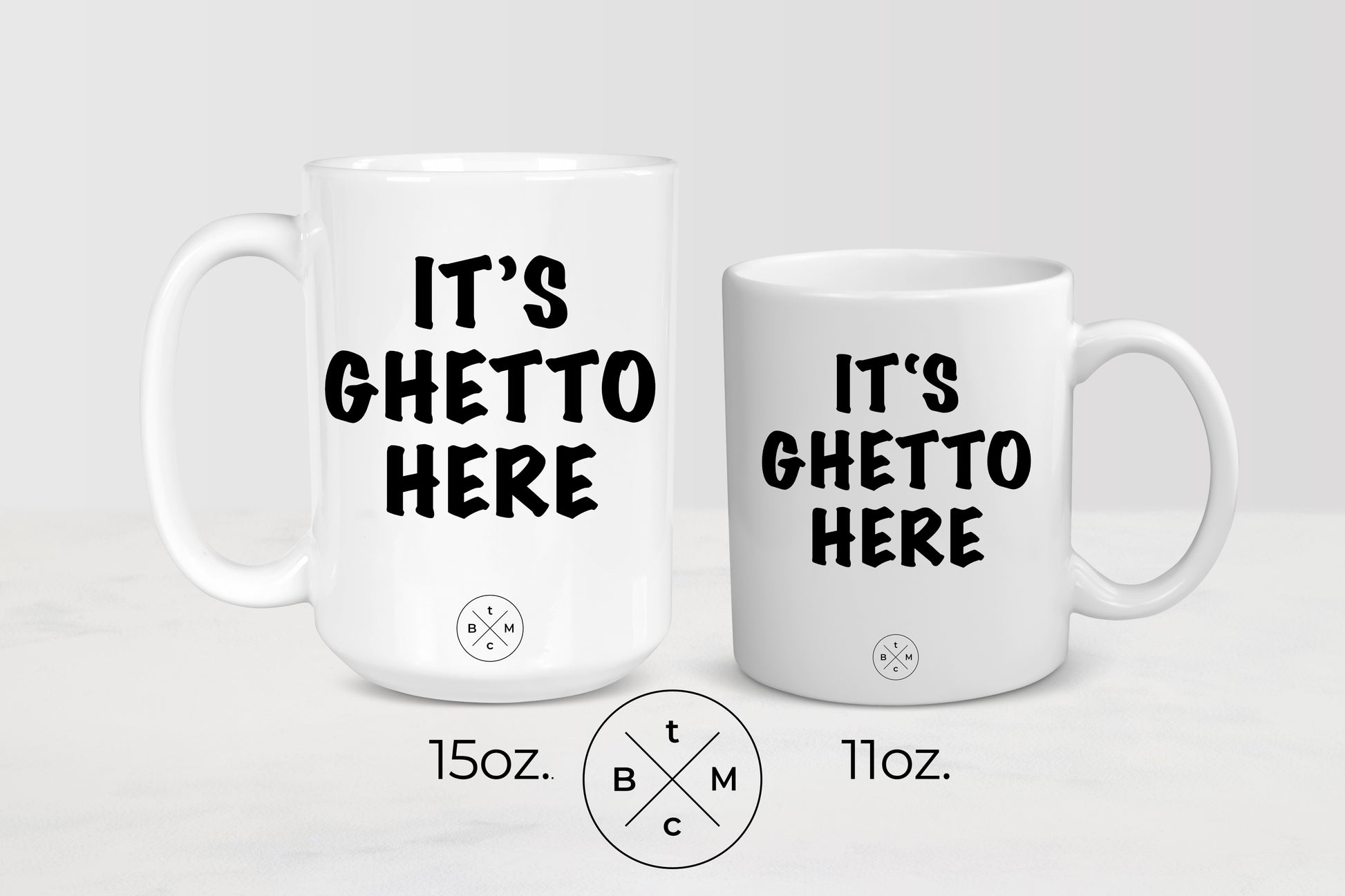 White 11 ounce and 15 ounce mugs with black text it’s ghetto here 