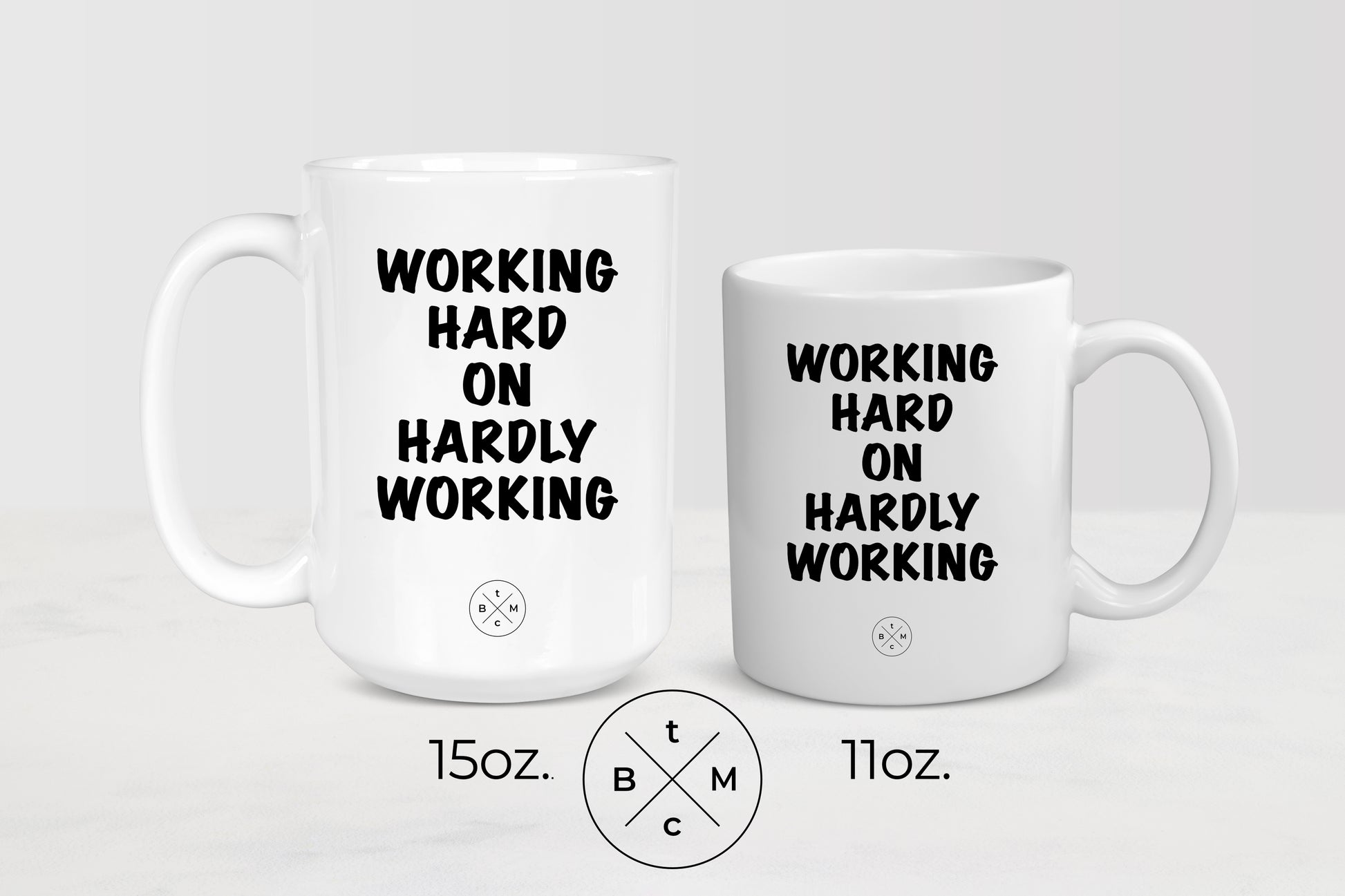11 ounce and 15 ounce white ceramic mugs with black text working hard on hardly working